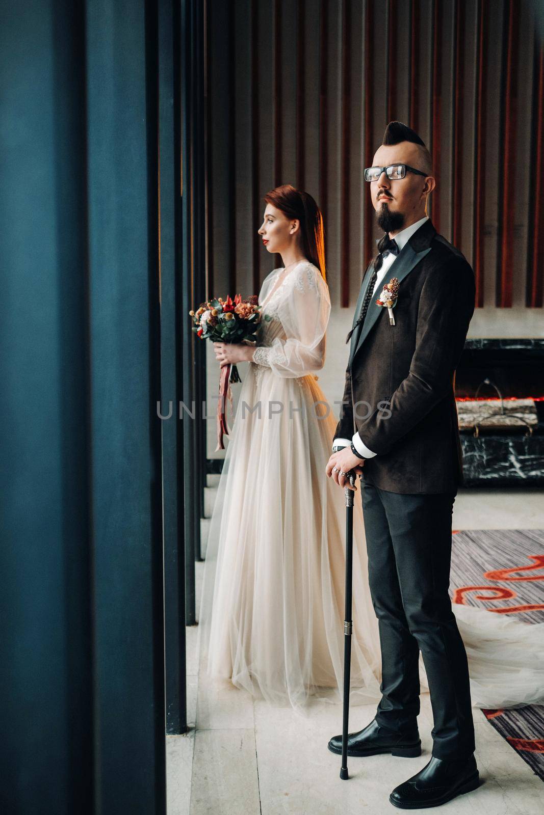 Stylish wedding couple in the interior. Glamorous bride and groom.