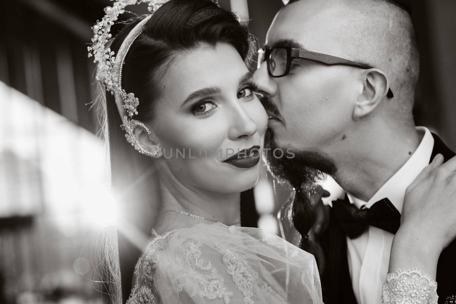Stylish wedding couple in the interior. Glamorous bride and groom, black and white photo by Lobachad
