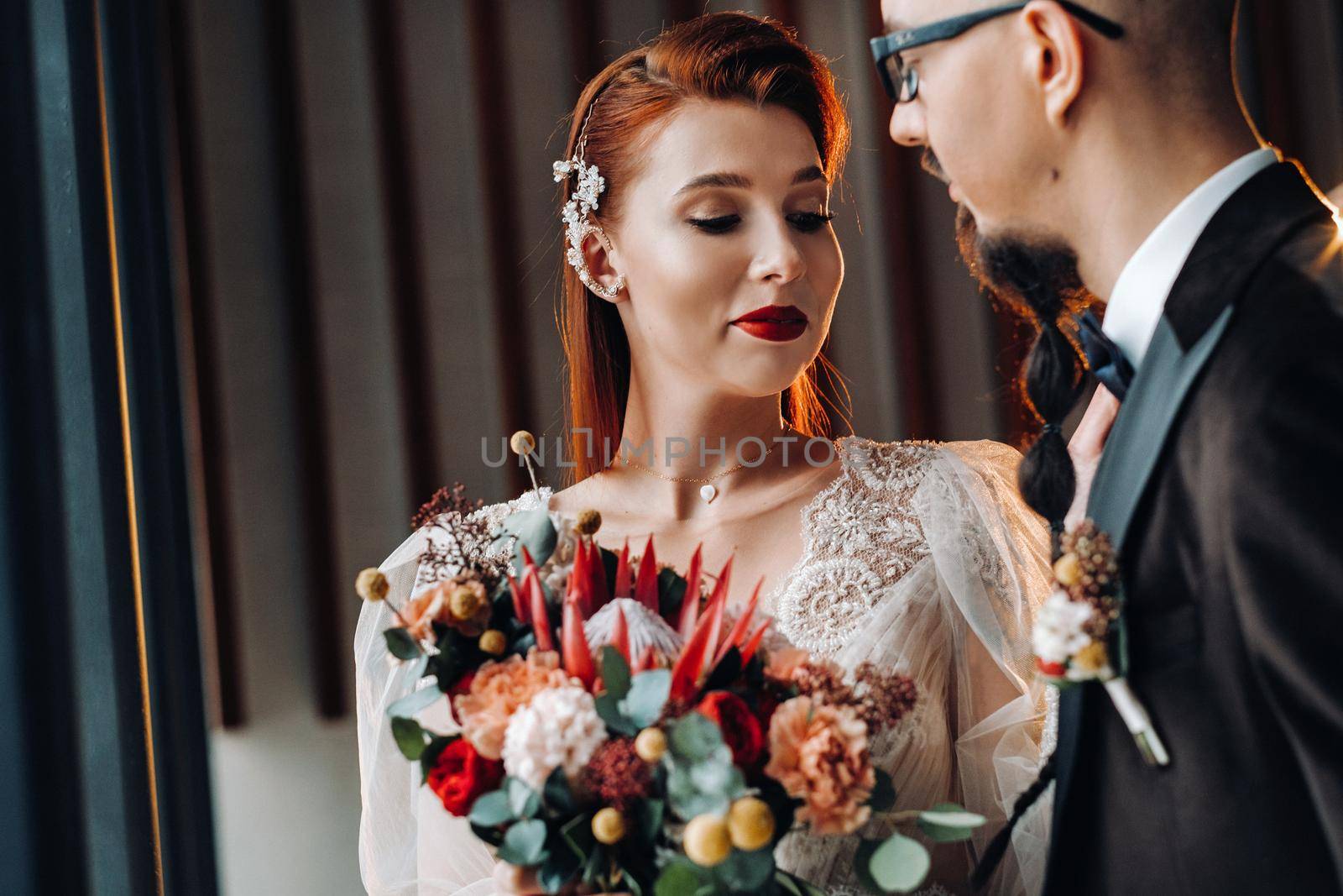 Stylish wedding couple in the interior. Glamorous bride and groom.