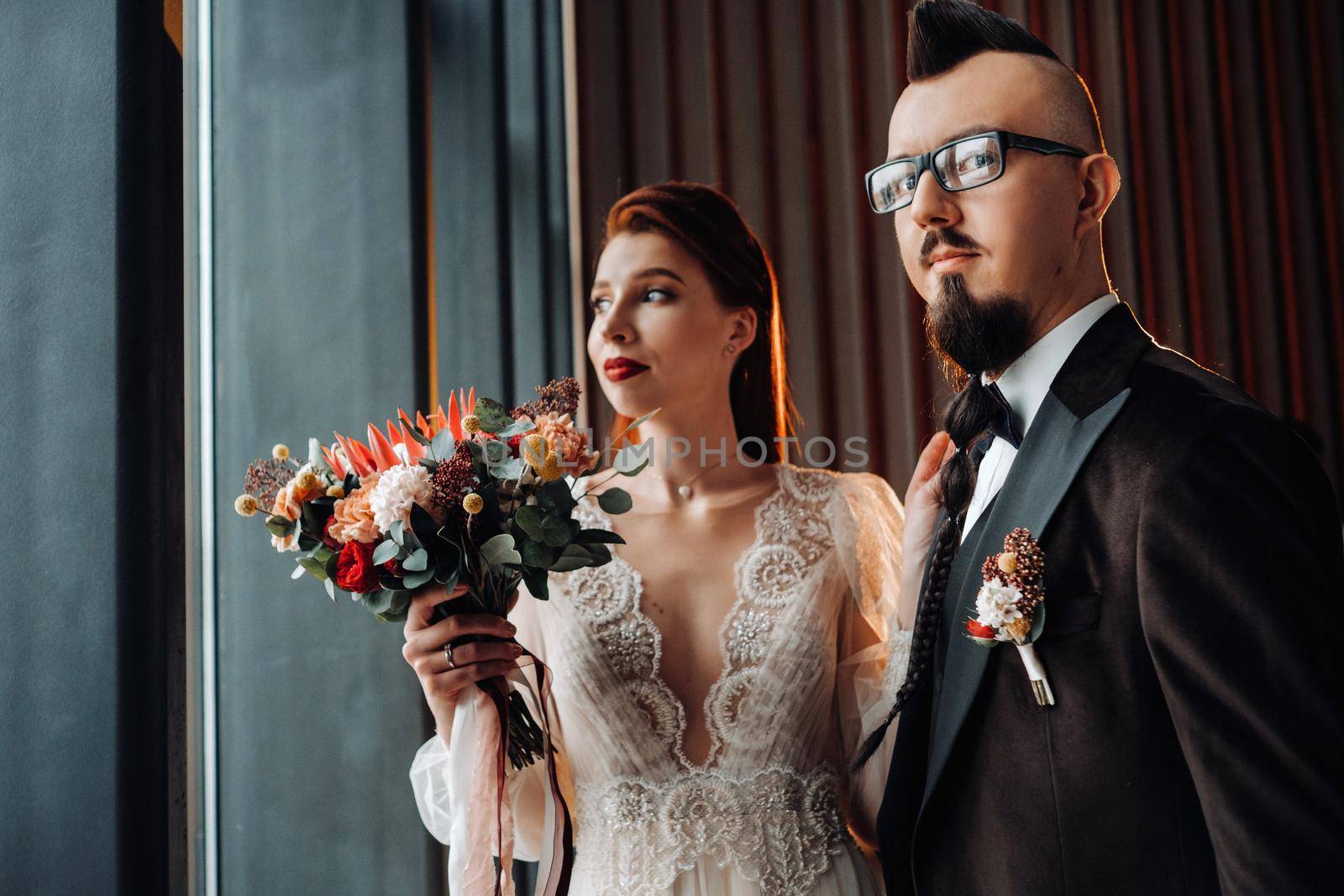 Stylish wedding couple in the interior. Glamorous bride and groom.