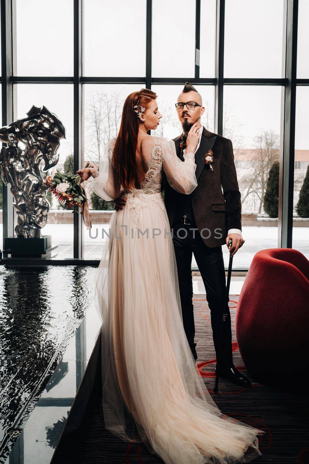 Stylish wedding couple in the interior. Glamorous bride and groom.