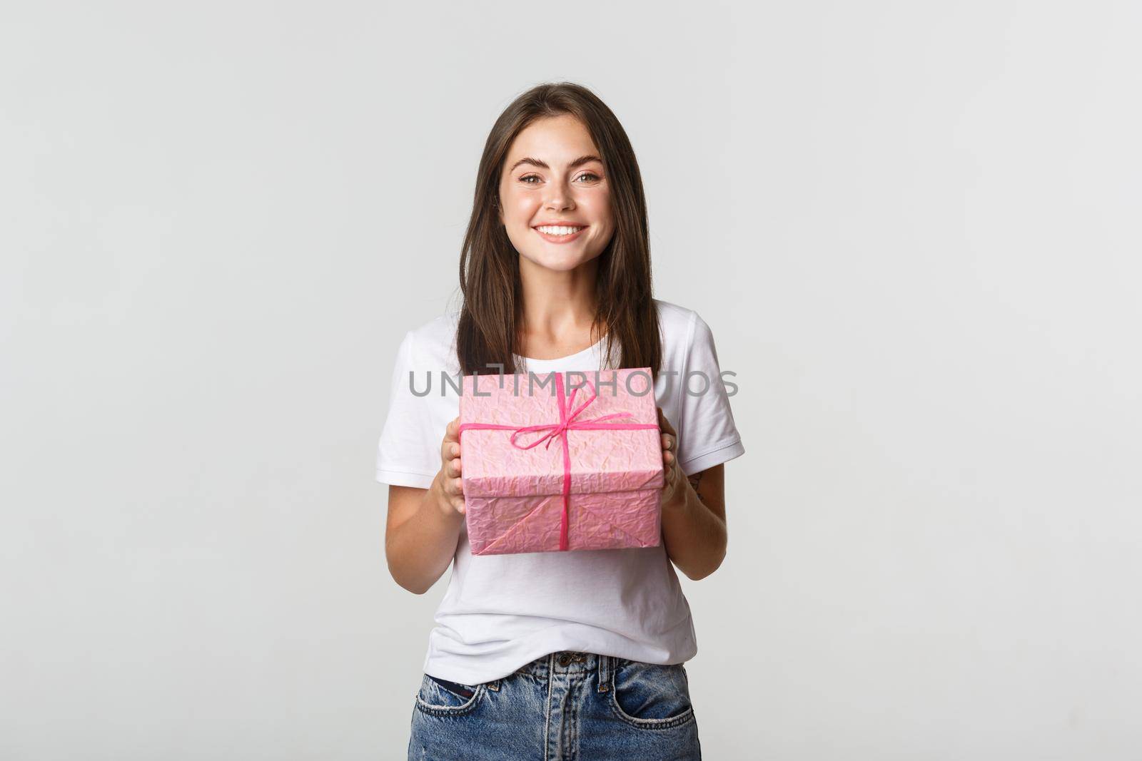 Surprised happy birthday girl receiving wrapped gift, white background.