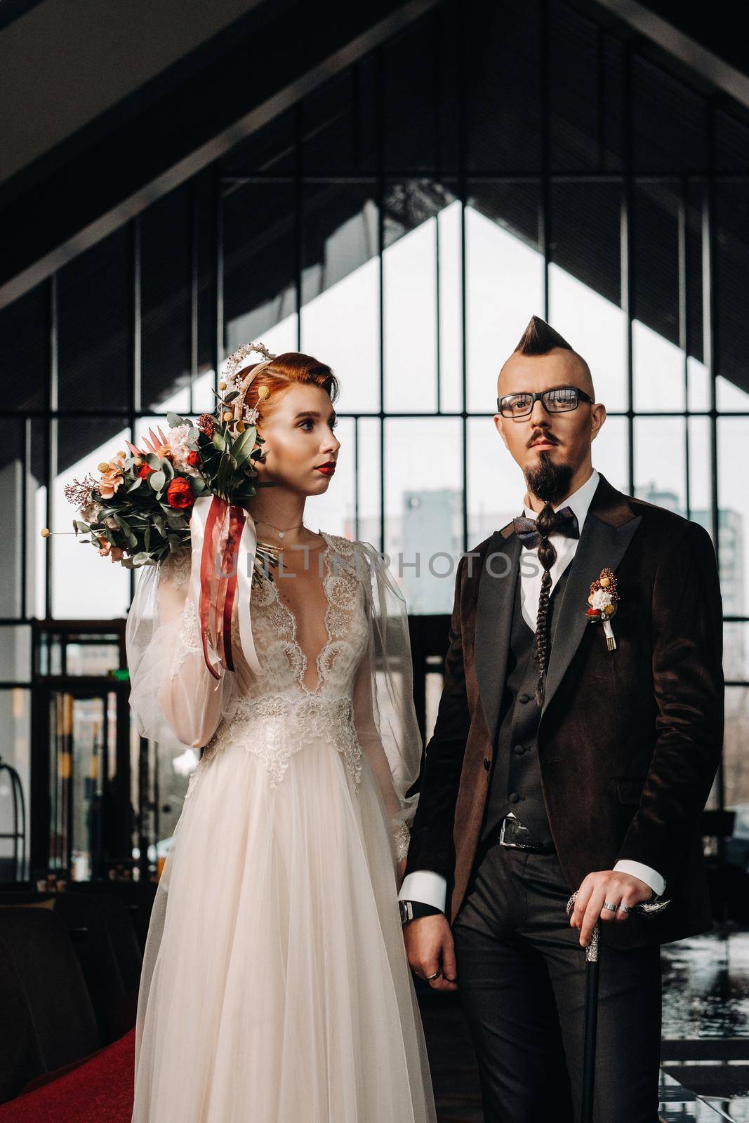 Stylish wedding couple in the interior. Glamorous bride and groom.