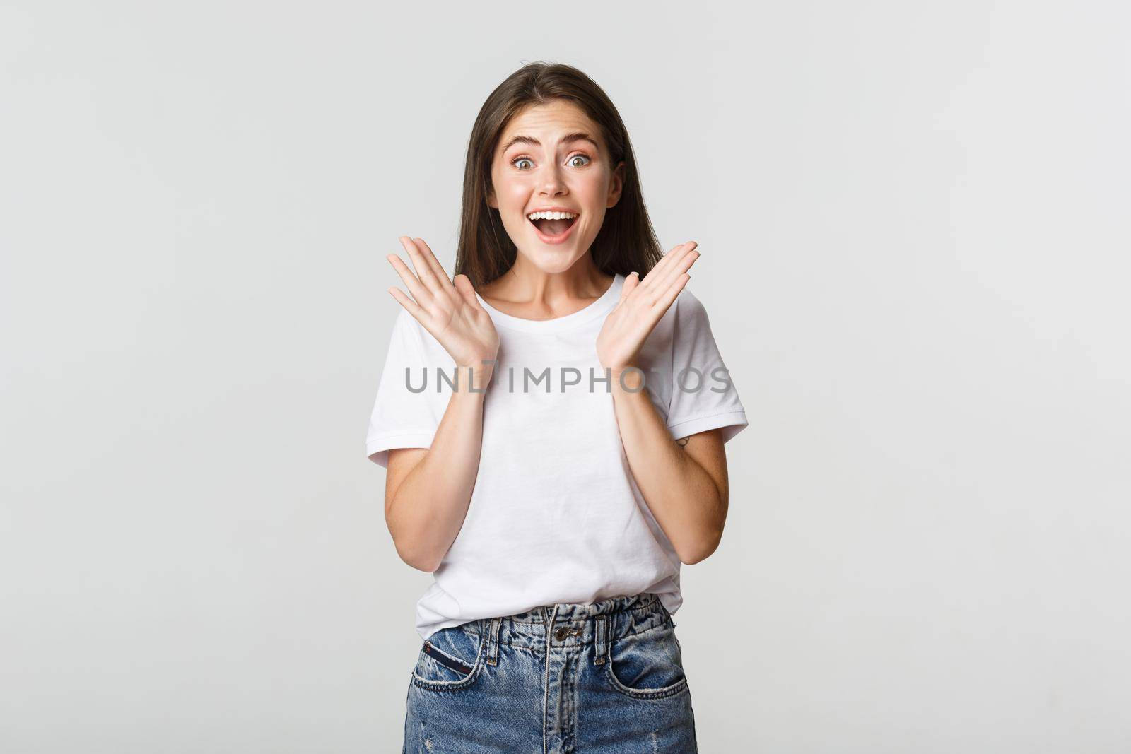 Excited hopeful girl clap hands and looking fascinated.