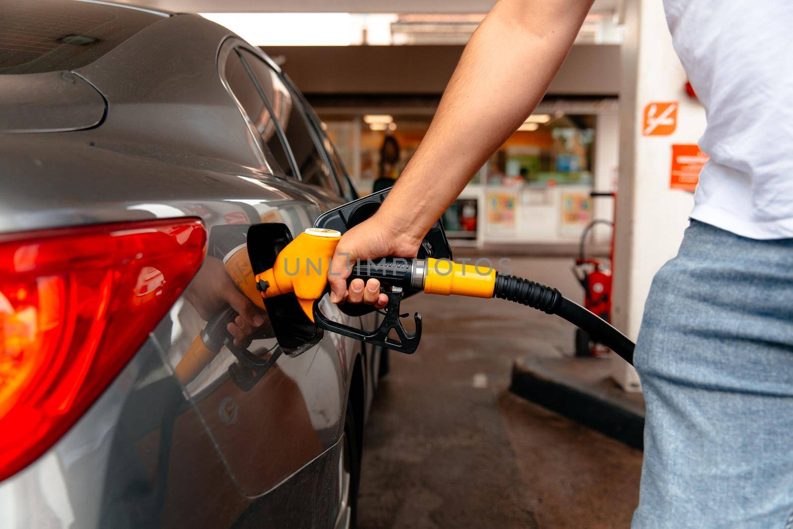 Man fill diesel tank of car in gas station by RecCameraStock