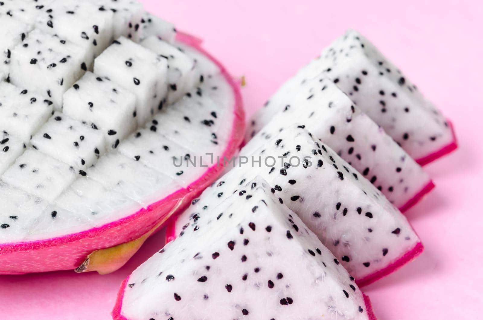 Fresh dragon fruit slice on pink background.