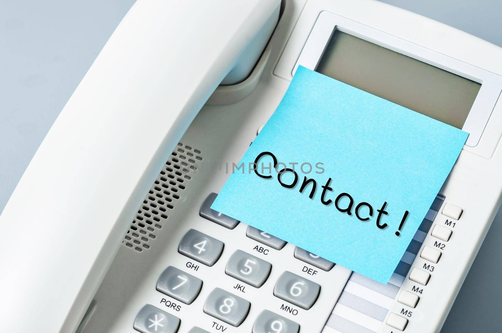Handwritten CONTACT message on sticky note attach to IP phone.