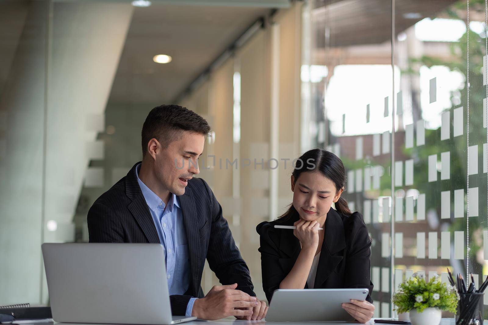 Diverse business people working together with laptop and digital tablet in office meeting room