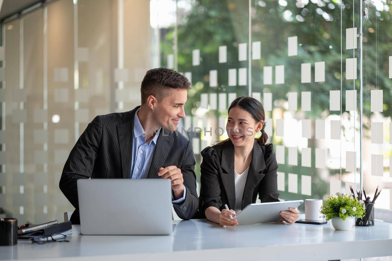 Diverse business people working together with laptop and digital tablet in office meeting room