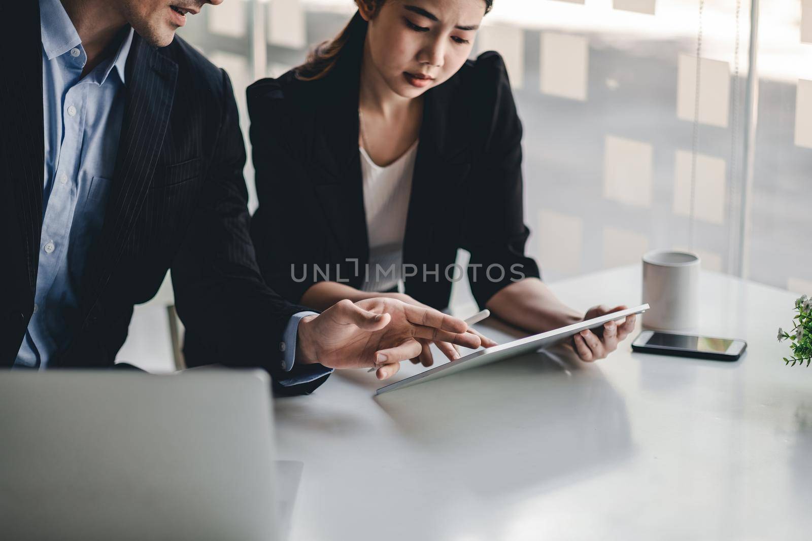 Diverse business people working together with digital tablet in office meeting room, colleague discussion about project work.