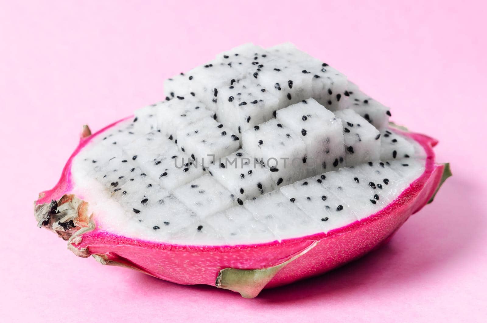 Fresh dragon fruit slice on pink background.