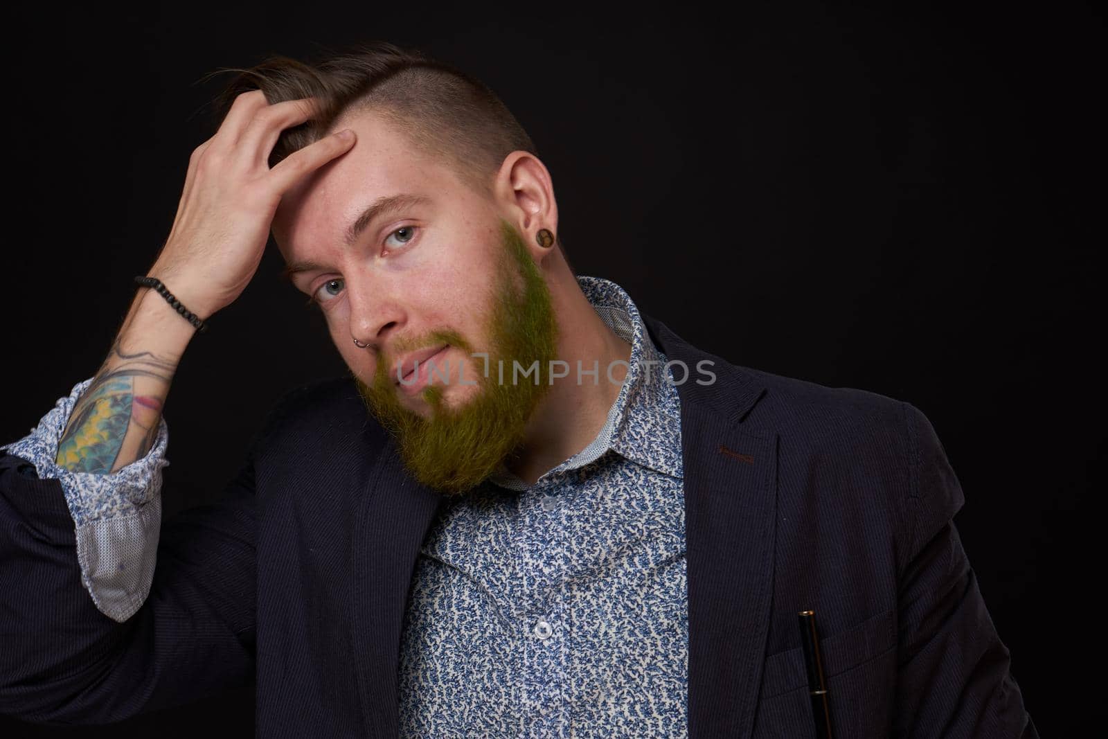 fashionable business man in a jacket with a beard posing. High quality photo