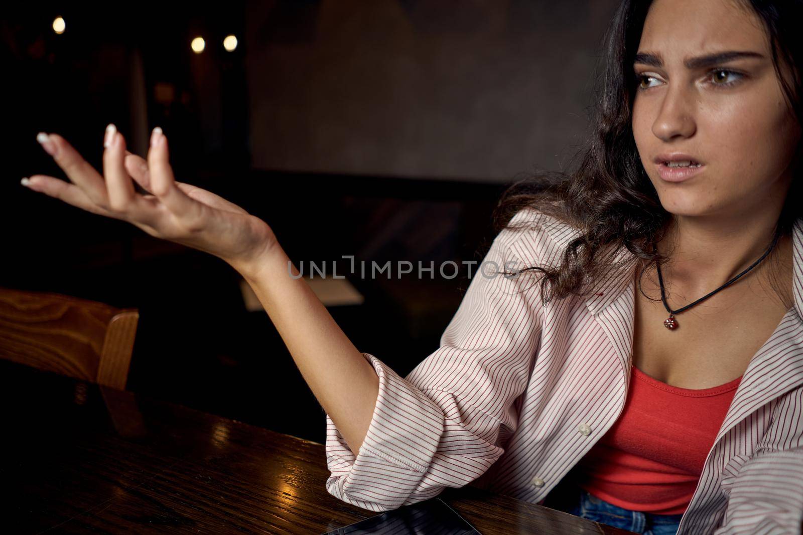 woman in a cafe at a table in front of a laptop device communication by Vichizh