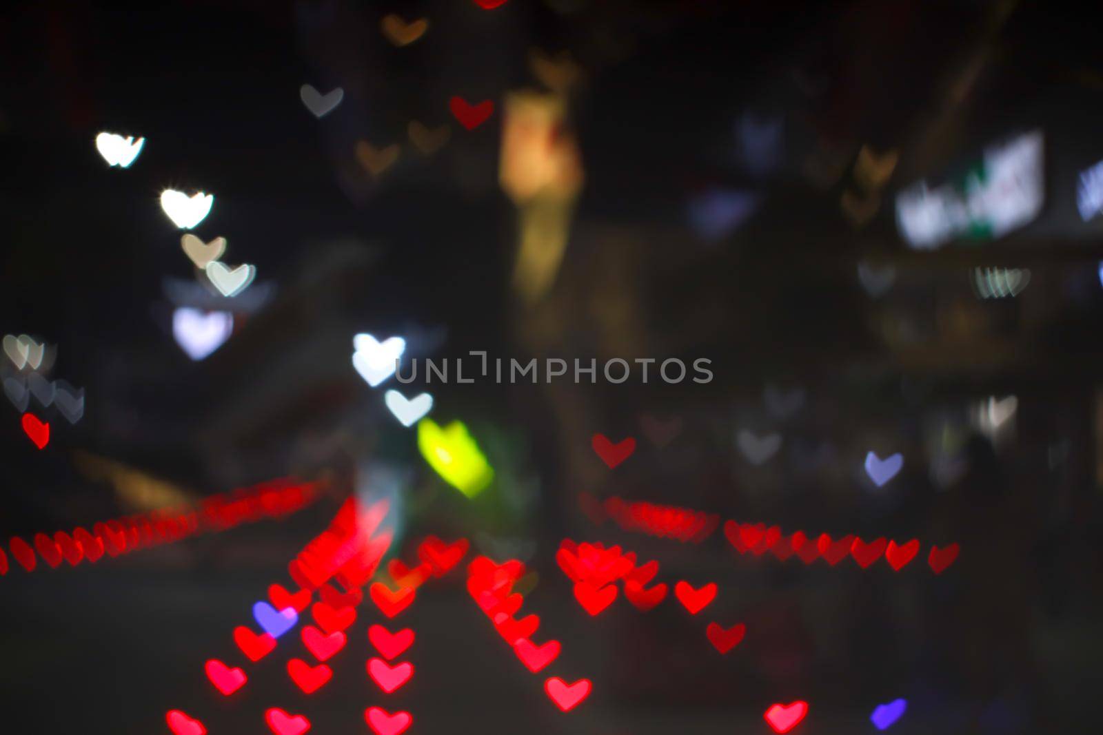 red bokeh and blur heart shape love valentine colorful night light on floor at shopping mall