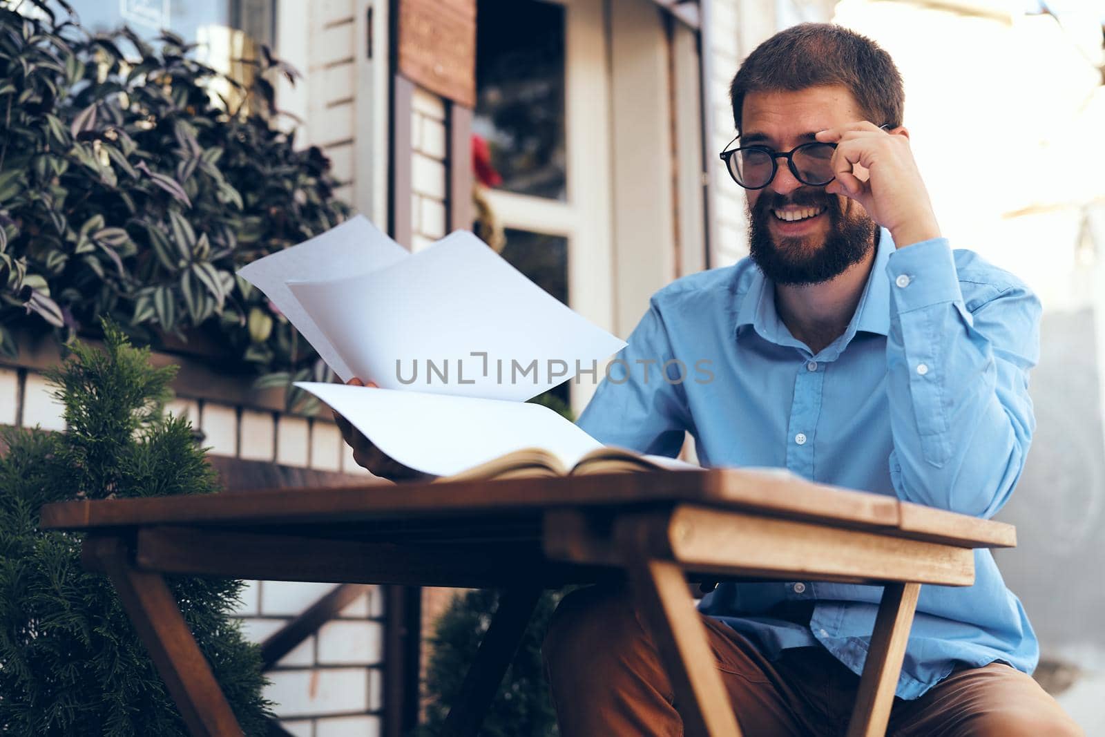 business man with glasses sitting at a table in a cafe work emotions. High quality photo