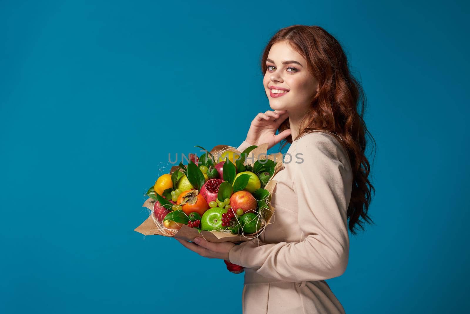 pretty woman beige coat fruit bouquet in hands isolated background by Vichizh