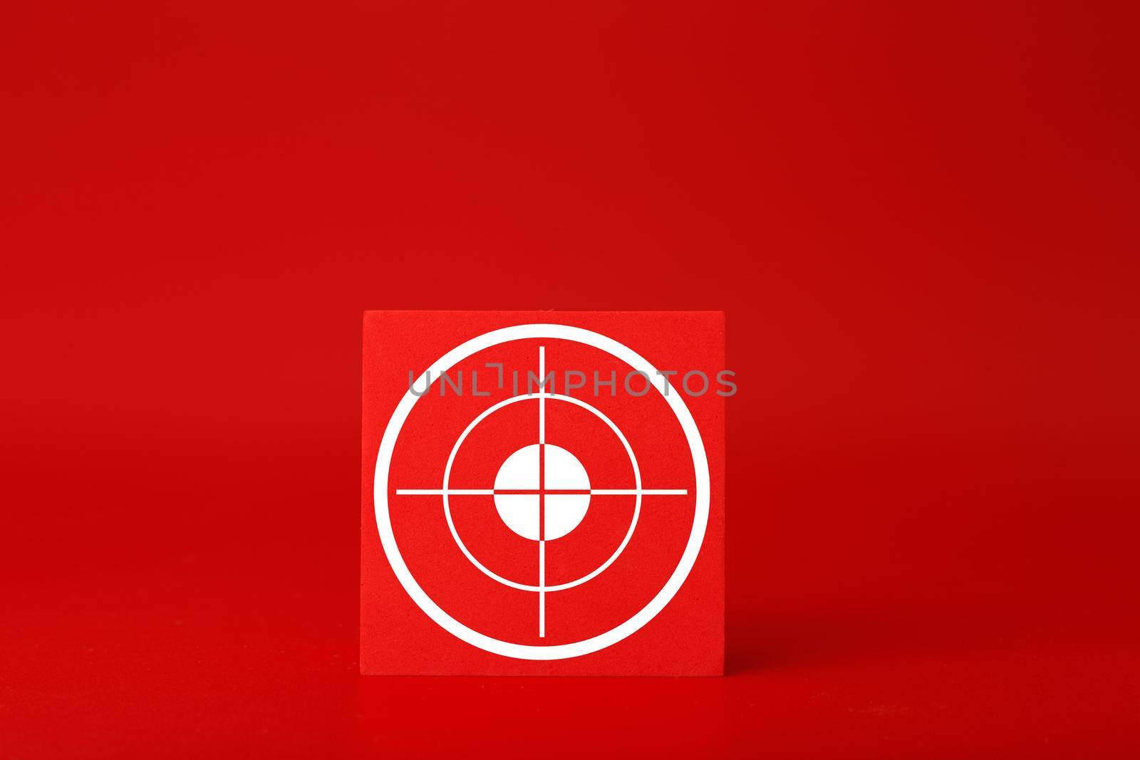 Goal symbol on red toy cube in the middle of red background. Concept of goal, success, reaching business and personal aims