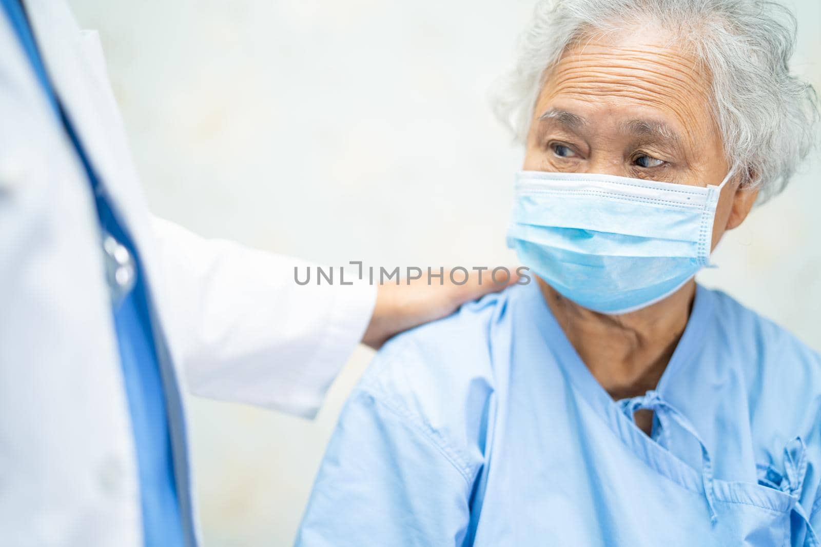Asian senior or elderly old lady woman patient wearing a face mask in hospital for protect safety infection and kill Novel Coronavirus Covid-19 virus.