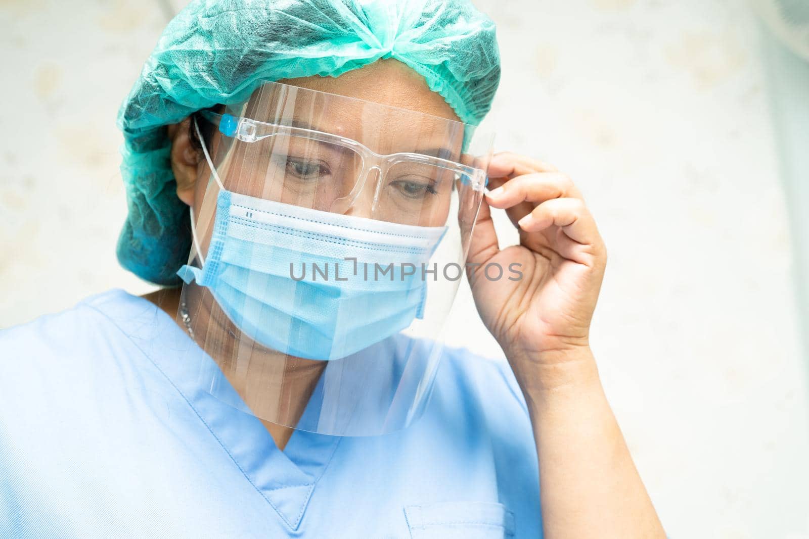 Asian doctor wearing face shield and PPE suit to check patient protect safety infection Covid-19 Coronavirus outbreak at quarantine nursing hospital ward. by pamai