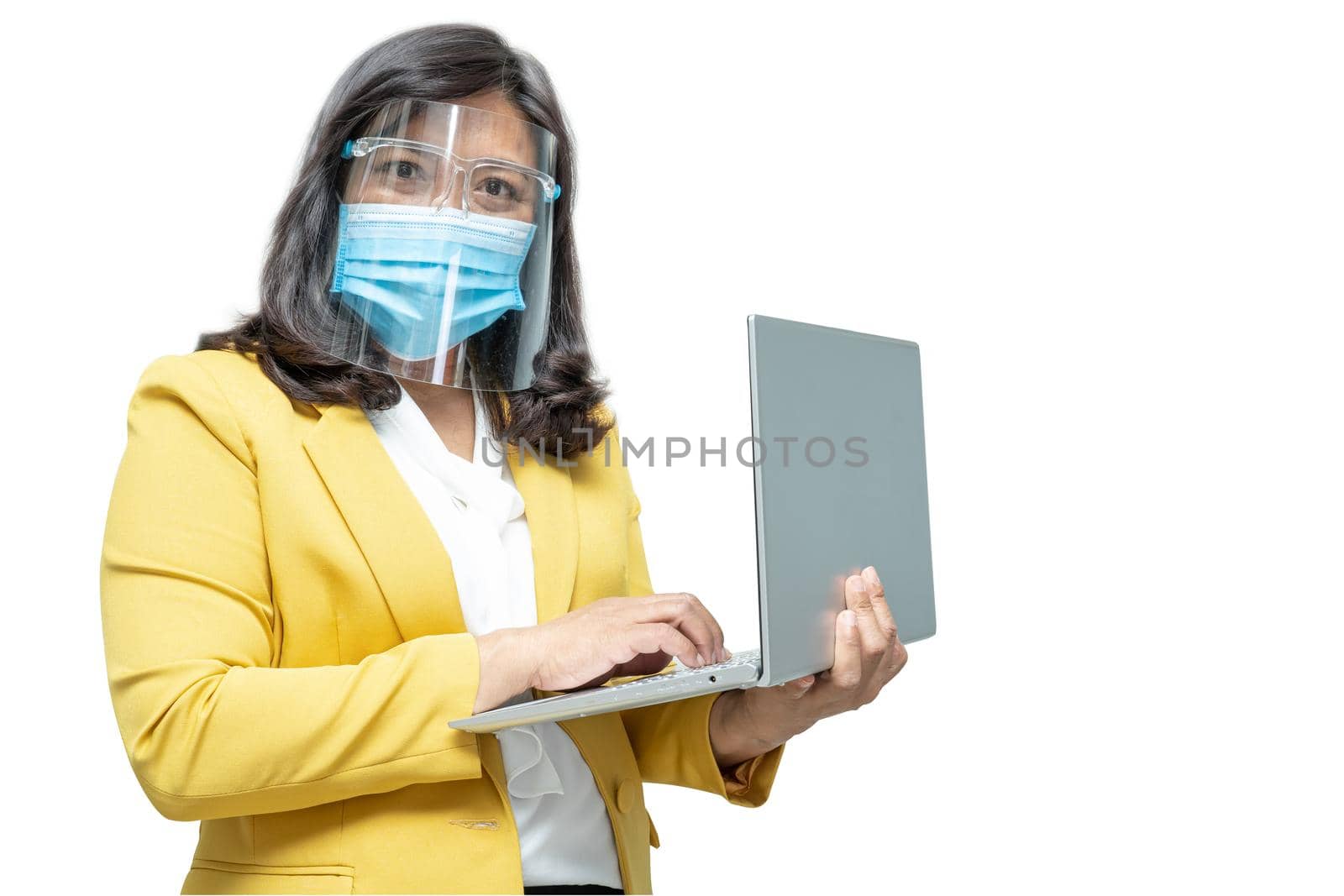 Asian business women use laptop notebook wearing mask and face shield on white background with clipping path, new normal to protect safety infection Covid-19 Coronavirus outbreak at office. by pamai