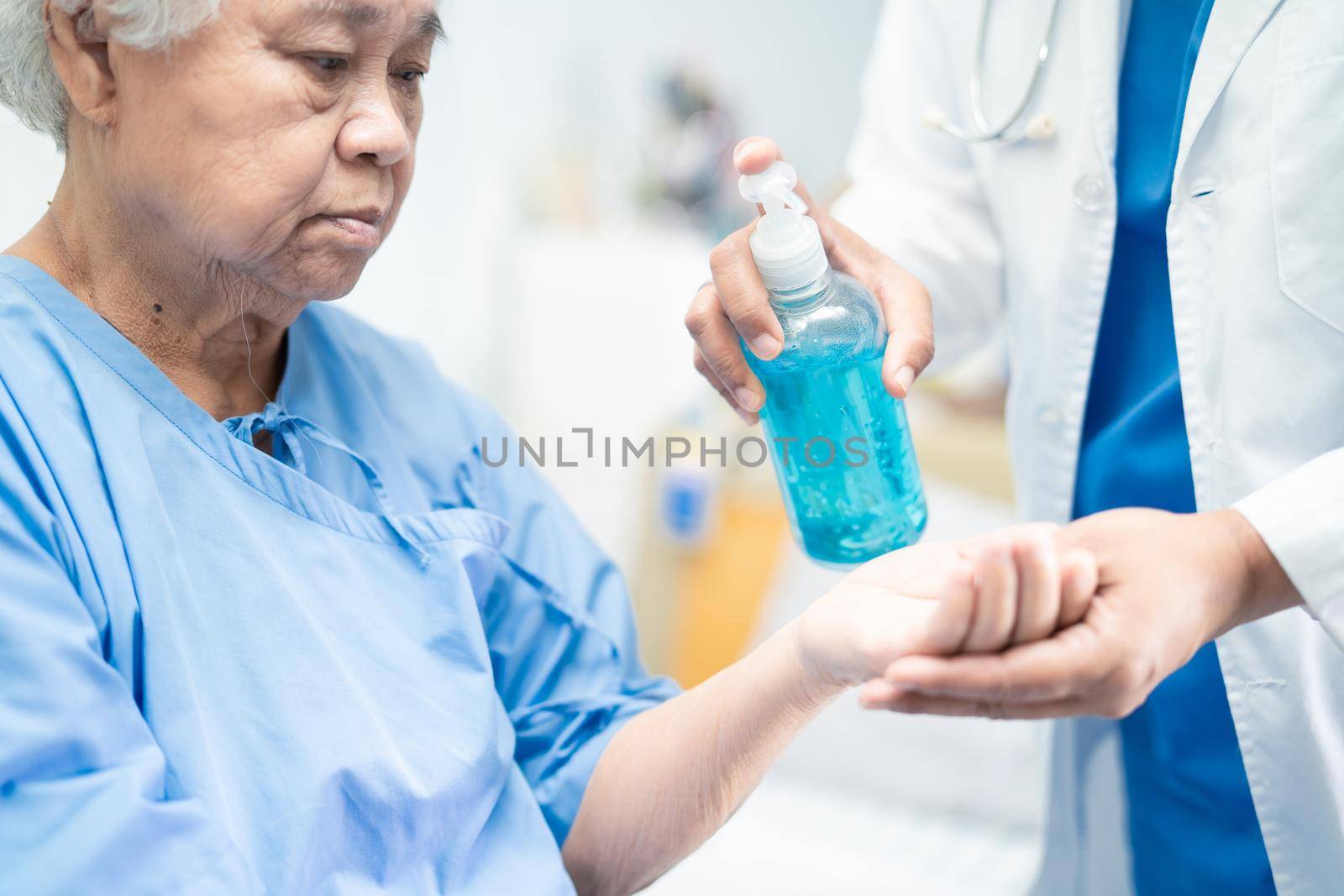 Doctor press press blue alcohol sanitizer gel to new normal after COVID-19 coronavirus pandemic. by pamai