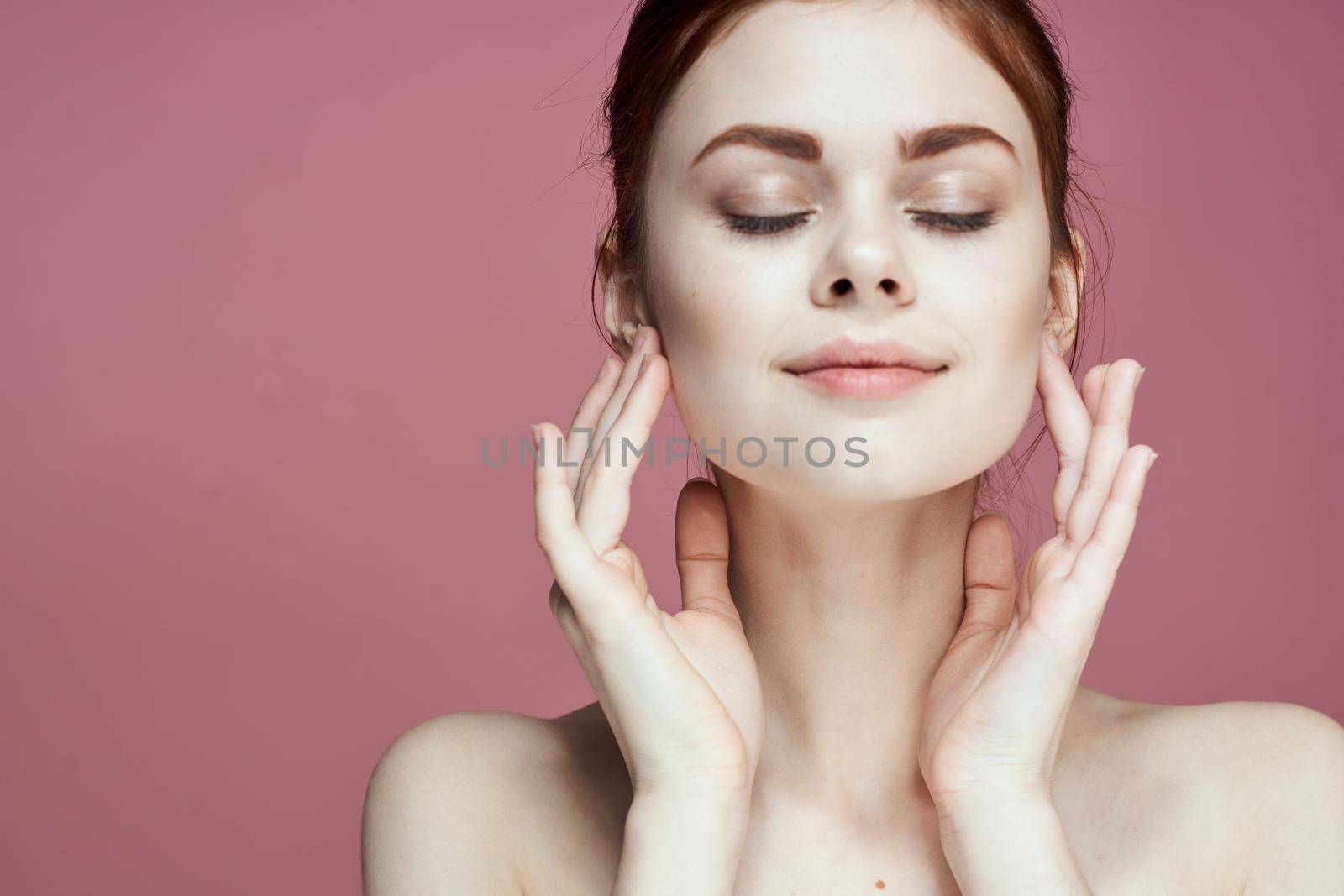 woman with bare shoulders charm cosmetics pink background posing. High quality photo