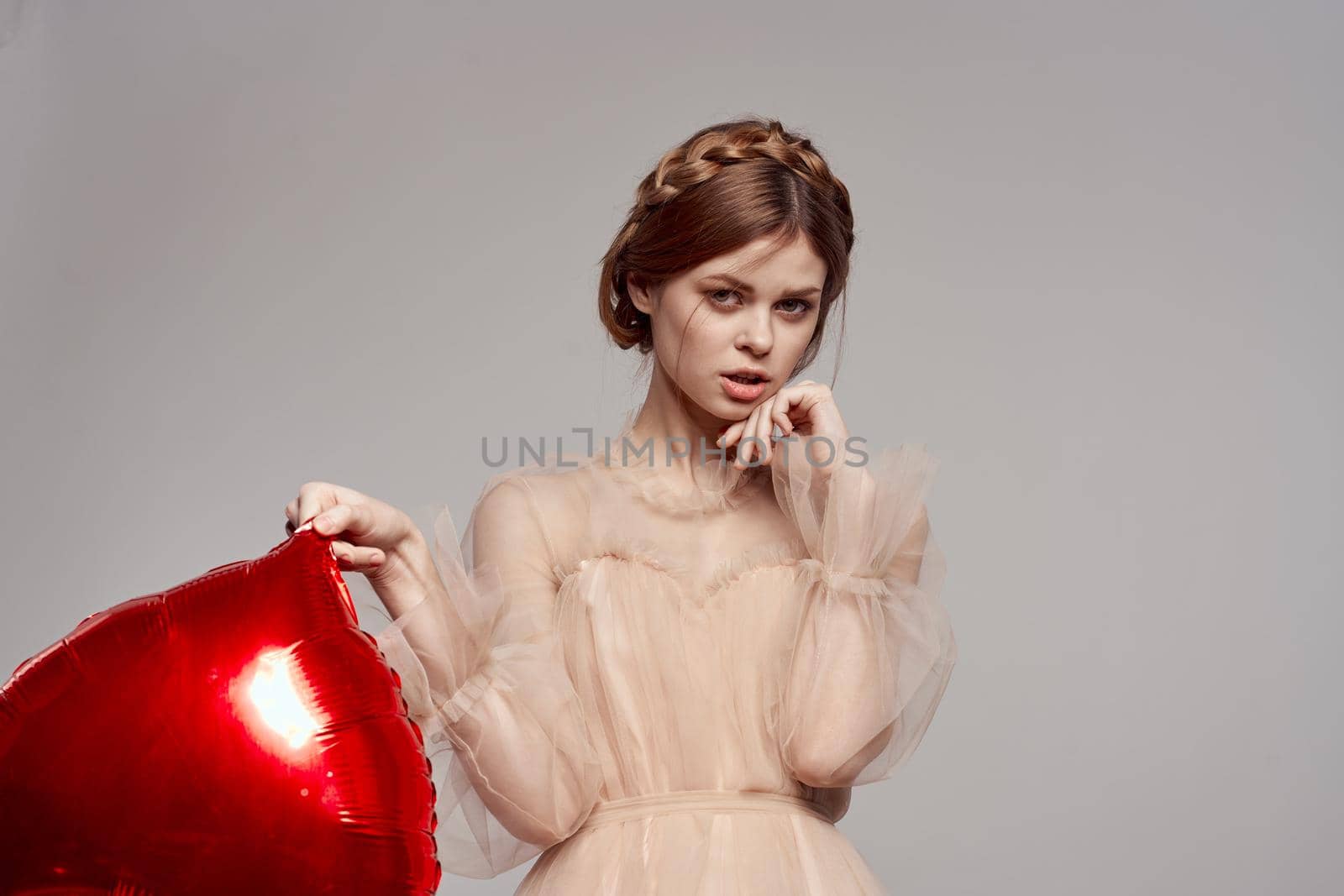 cheerful woman red heart in the hands of the balloon isolated background by Vichizh