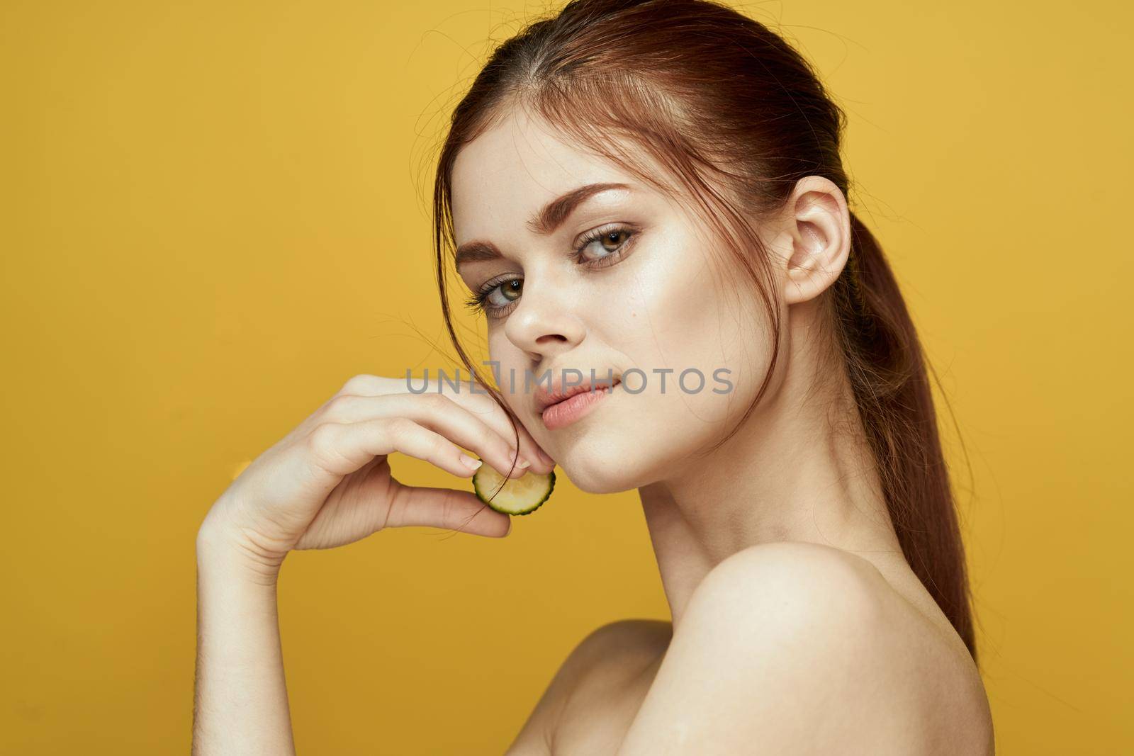 cheerful woman with cucumber vitamin skin care natural product. High quality photo