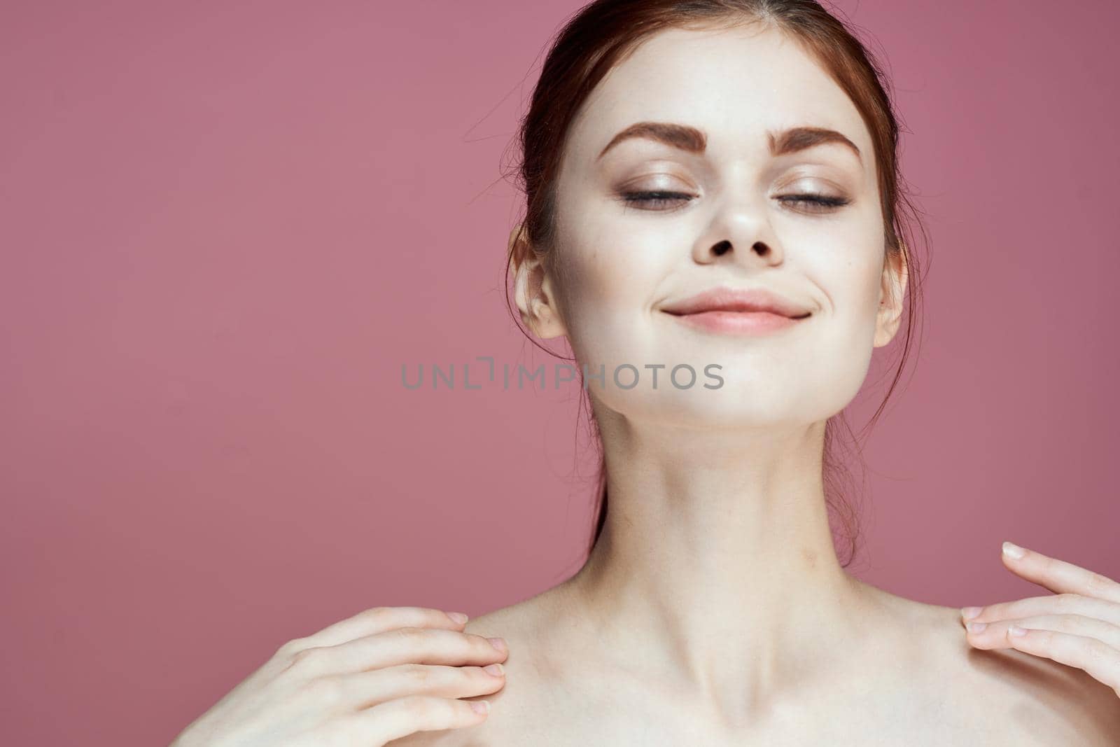 woman with bare shoulders charm cosmetics pink background posing. High quality photo