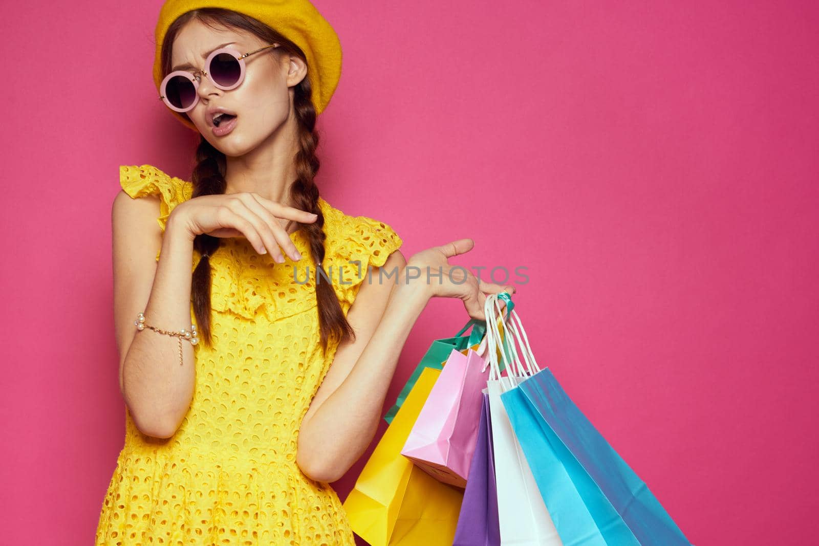 cheerful woman with multicolored bags posing pink background. High quality photo