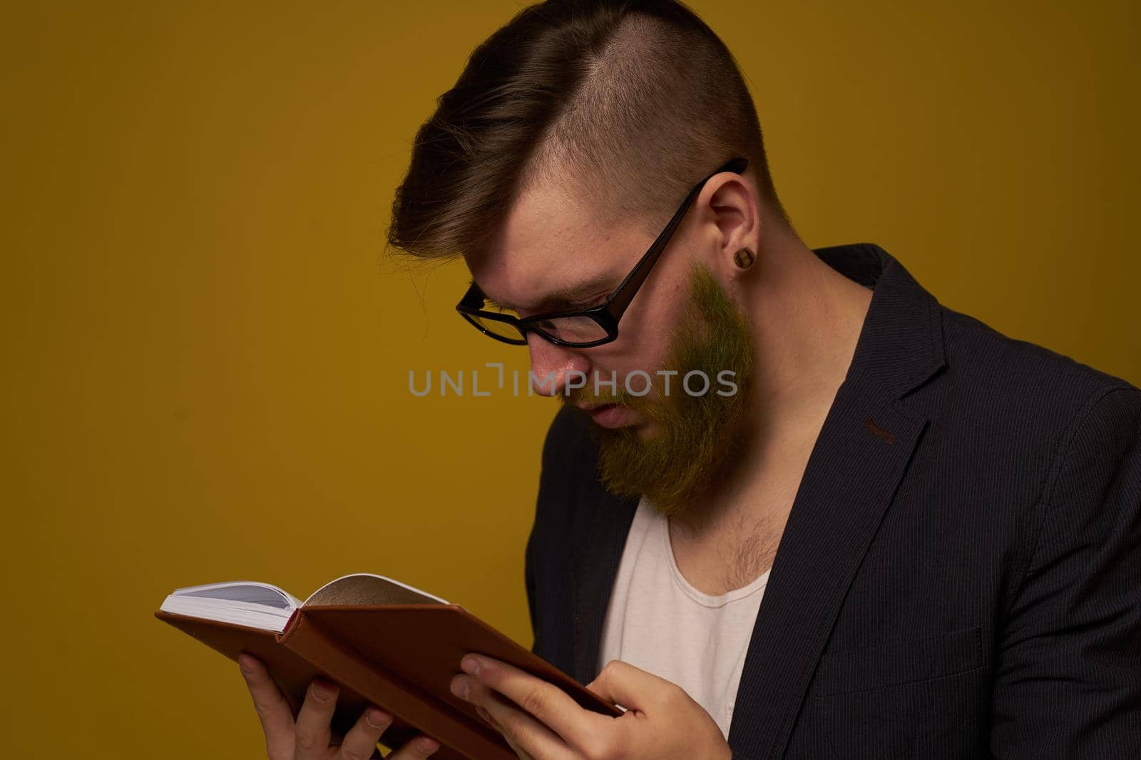 bearded man in a black jacket with a book in his hands education. High quality photo