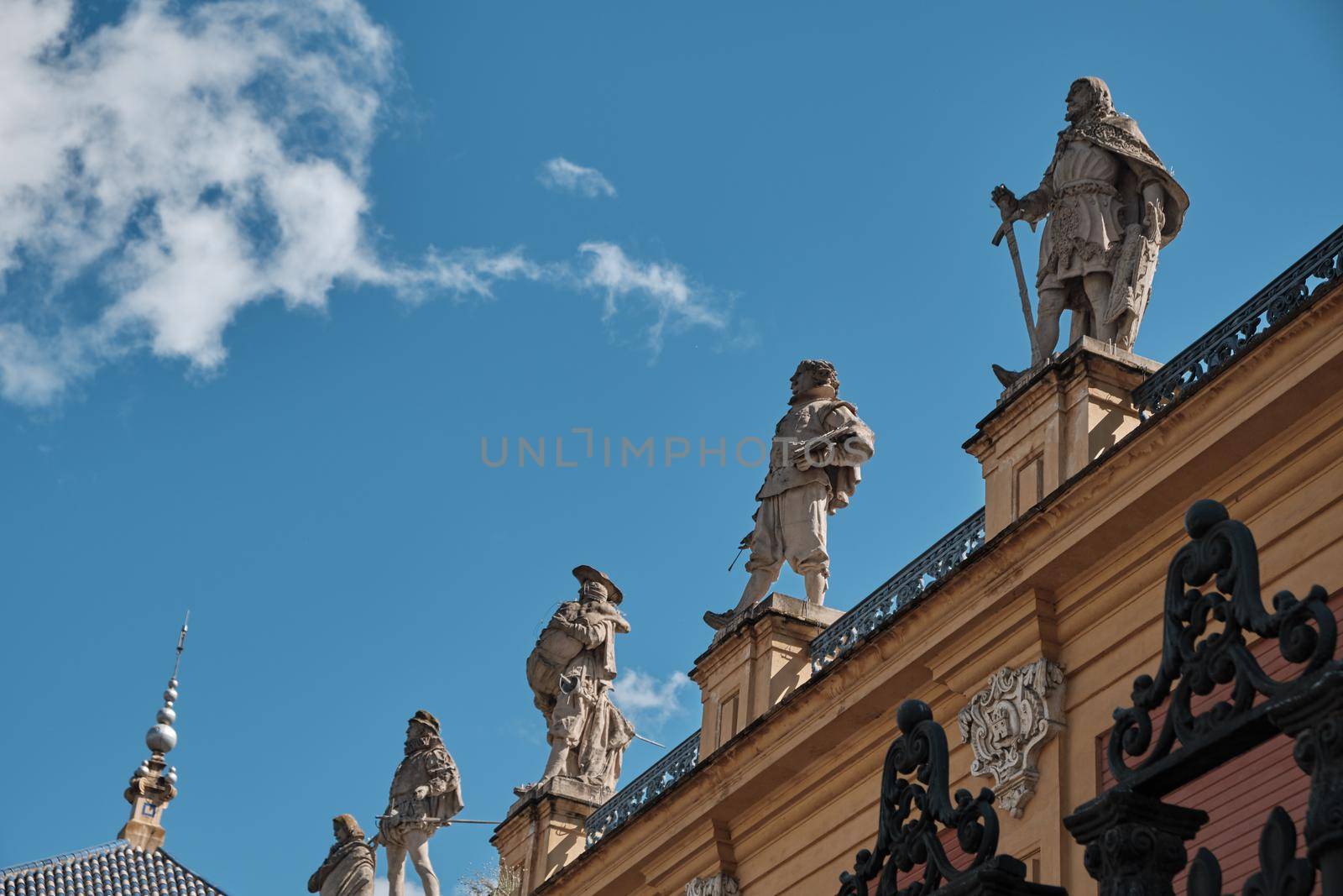 statue on old building in seville in a sunny day - spain - body copy - negative space - blue sky. by Sandronize