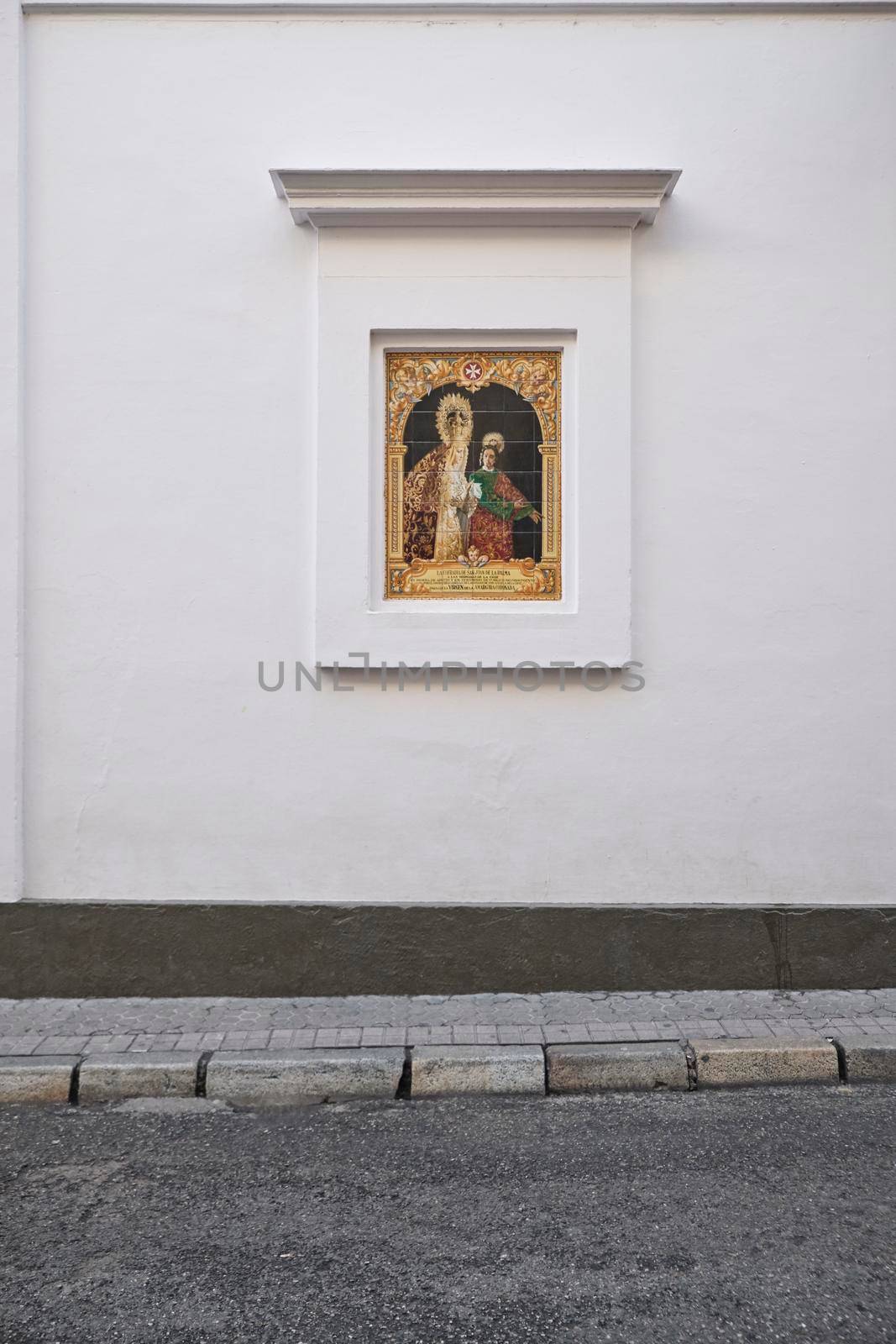 April 2019 Typical decorated religious representation in the white facade in Seville, Andalusia, Spain
