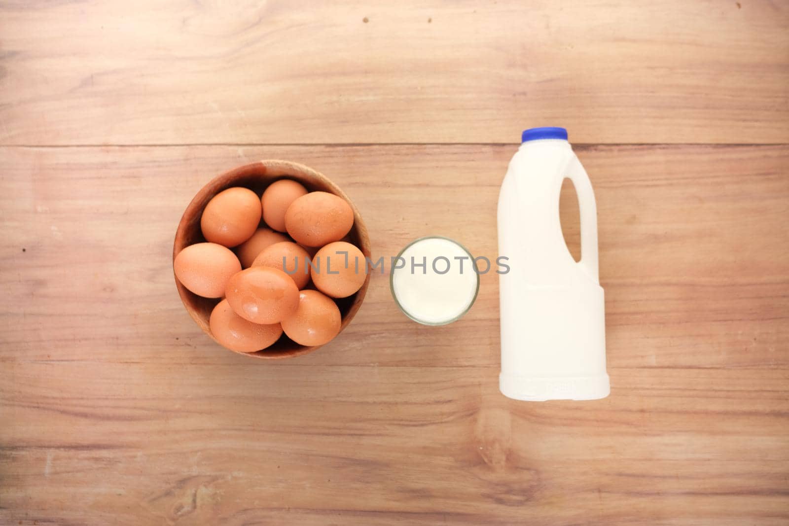 eggs in a bow and a glass of milk on table ,