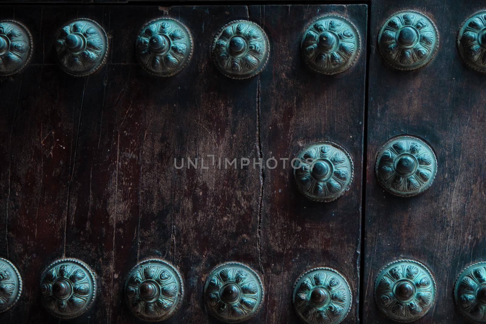 Close-up of old studded door detail with multiple decorative studs. by Sandronize