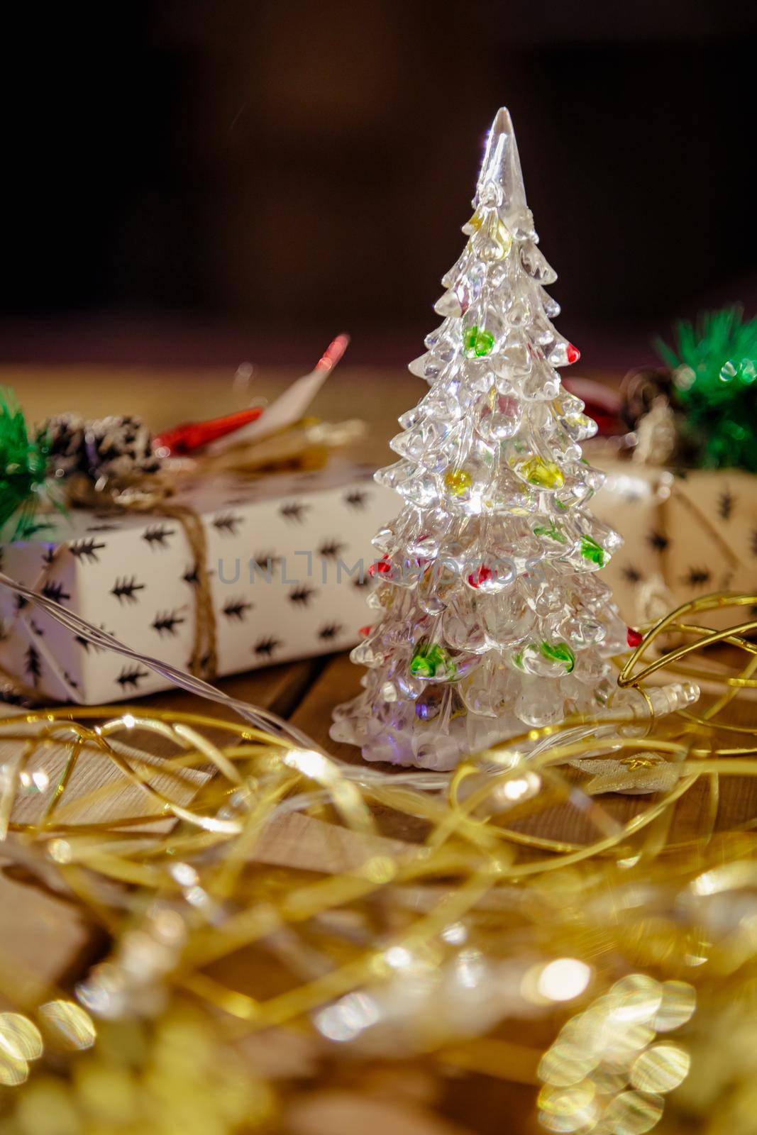 Christmas new year boxes with surprise and red bow. Yellow garland, lights in a dark room.