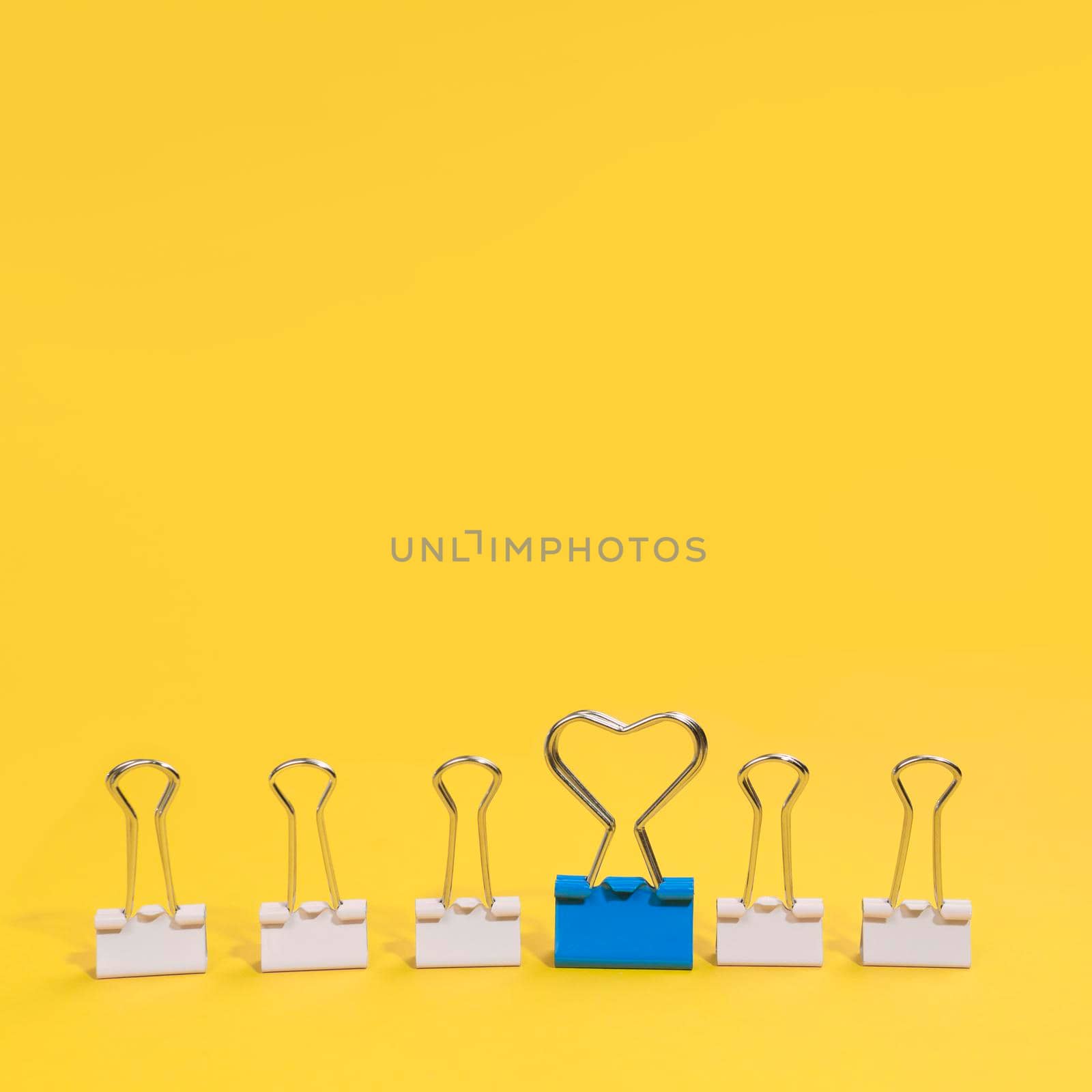 arrangement paper clips with one blue paper clip. High quality photo by Zahard