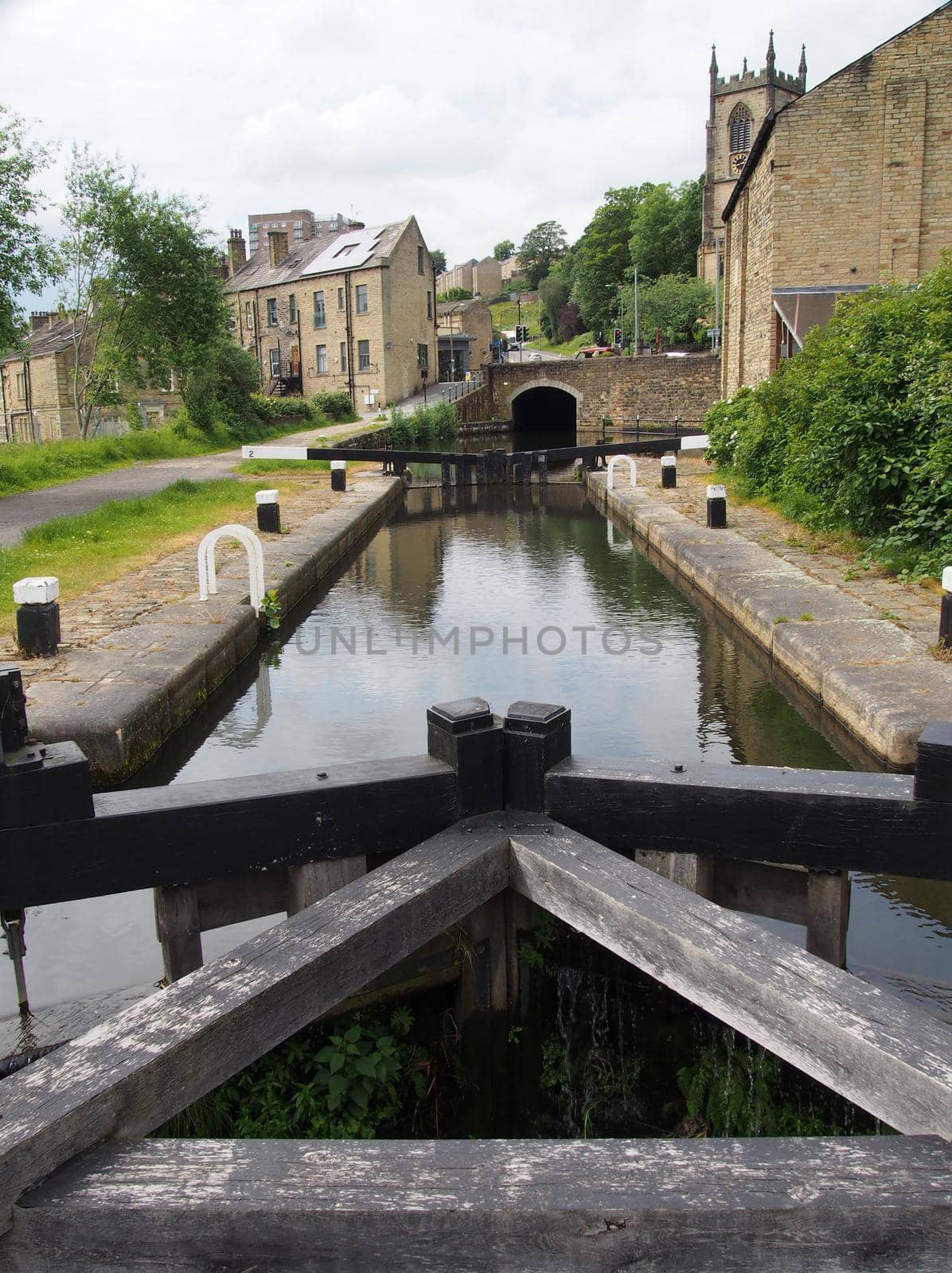 the wooden lock gates on the aire and calder navigation canal with a view of the west yorkshire town of sowerby bridge