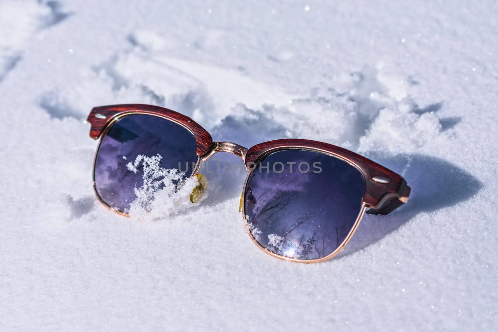 Forgotten or lost by someone sunglasses on white snow in winter