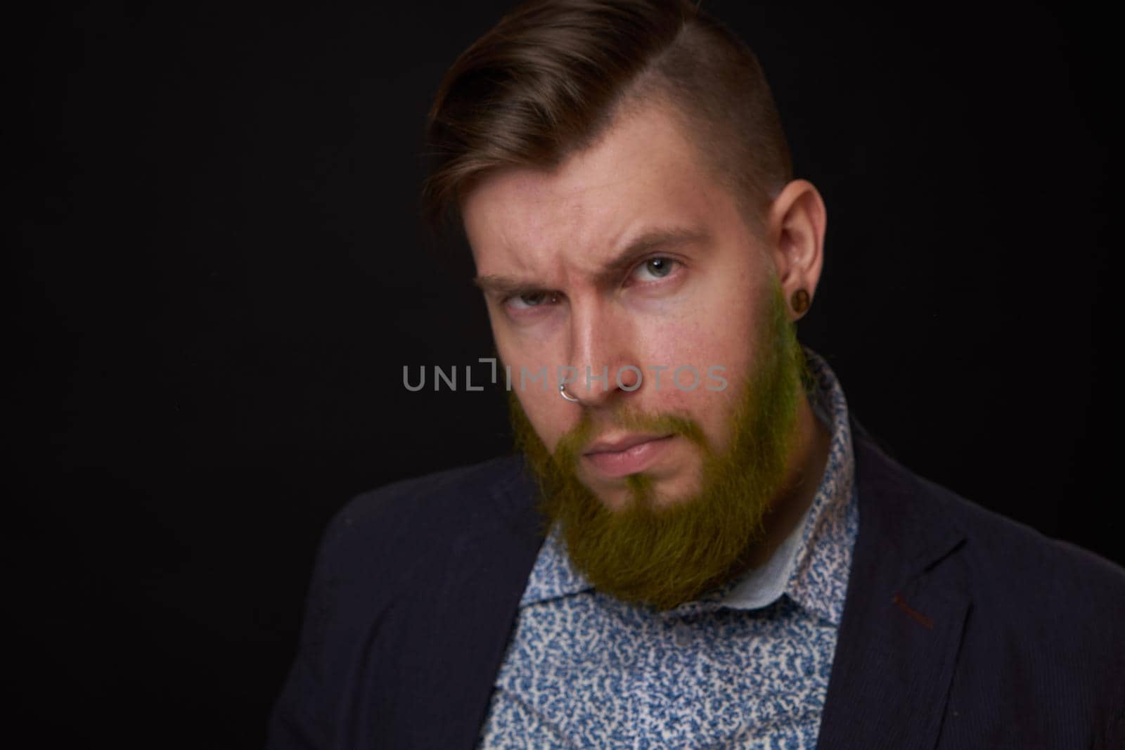 fashionable business man in a jacket with a beard posing. High quality photo