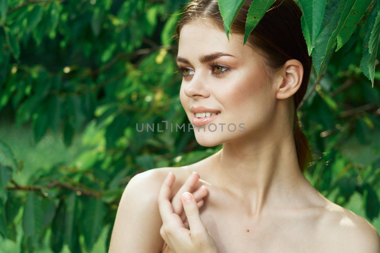 smiling woman skin care bare shoulders green leaves nature cropped view. High quality photo
