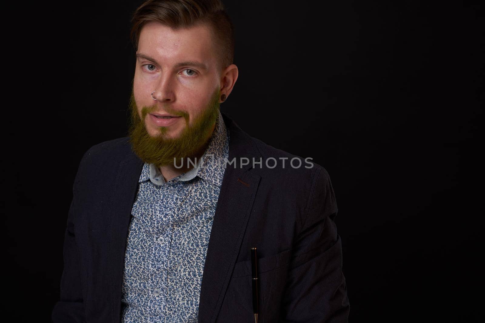 fashionable business man in a jacket with a beard posing. High quality photo