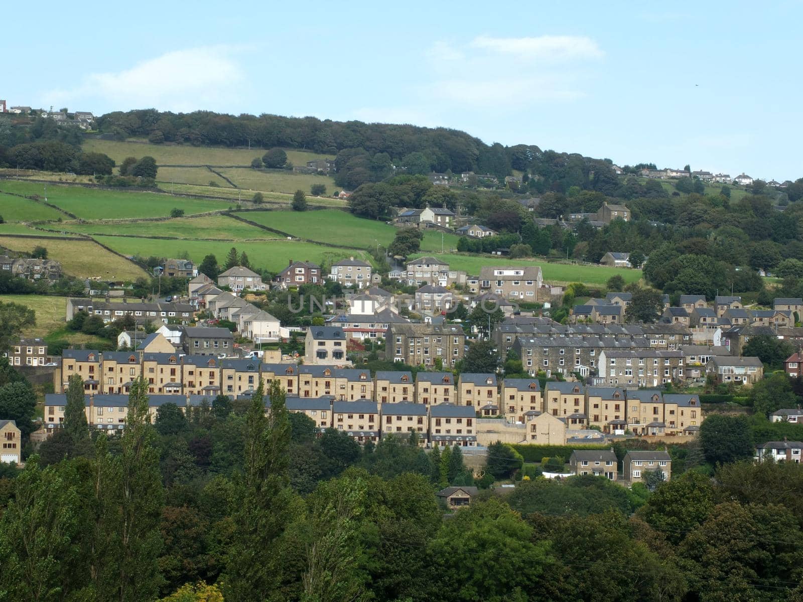 row of modern houses build on a hillside surrounded by older buildings in sowerby bridge west yorkshire by philopenshaw