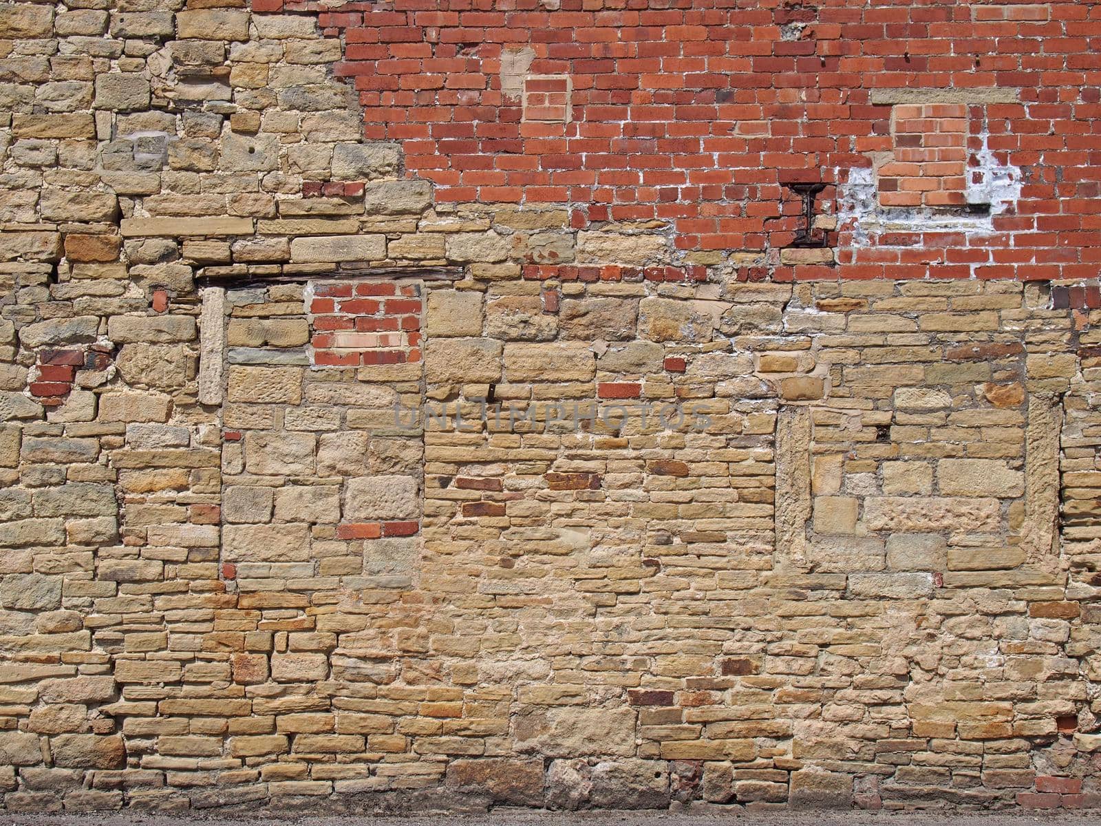 an old exterior wall with an irregular patched and repaired brick and stone surface