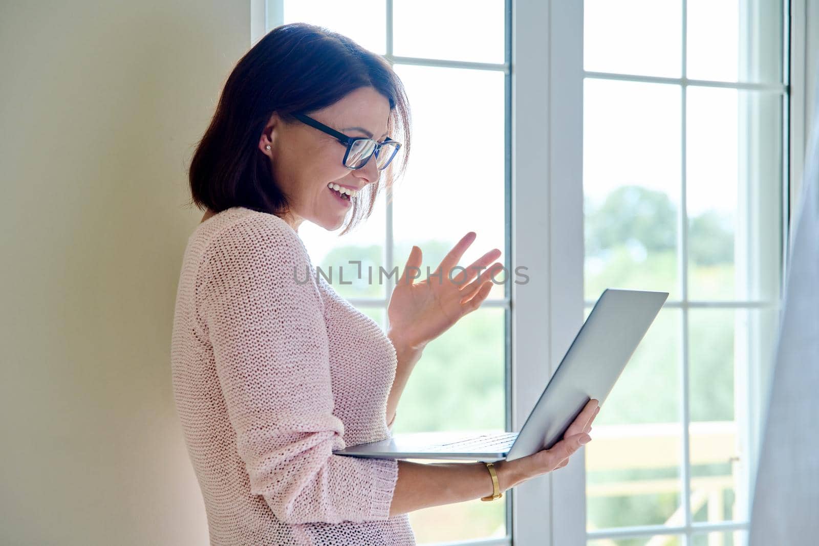 Video call, teleconference, online meeting, communication. Middle aged confident businesswoman, therapist, counselor, teacher, mentor with laptop, looking at screen talking consulting working remotely