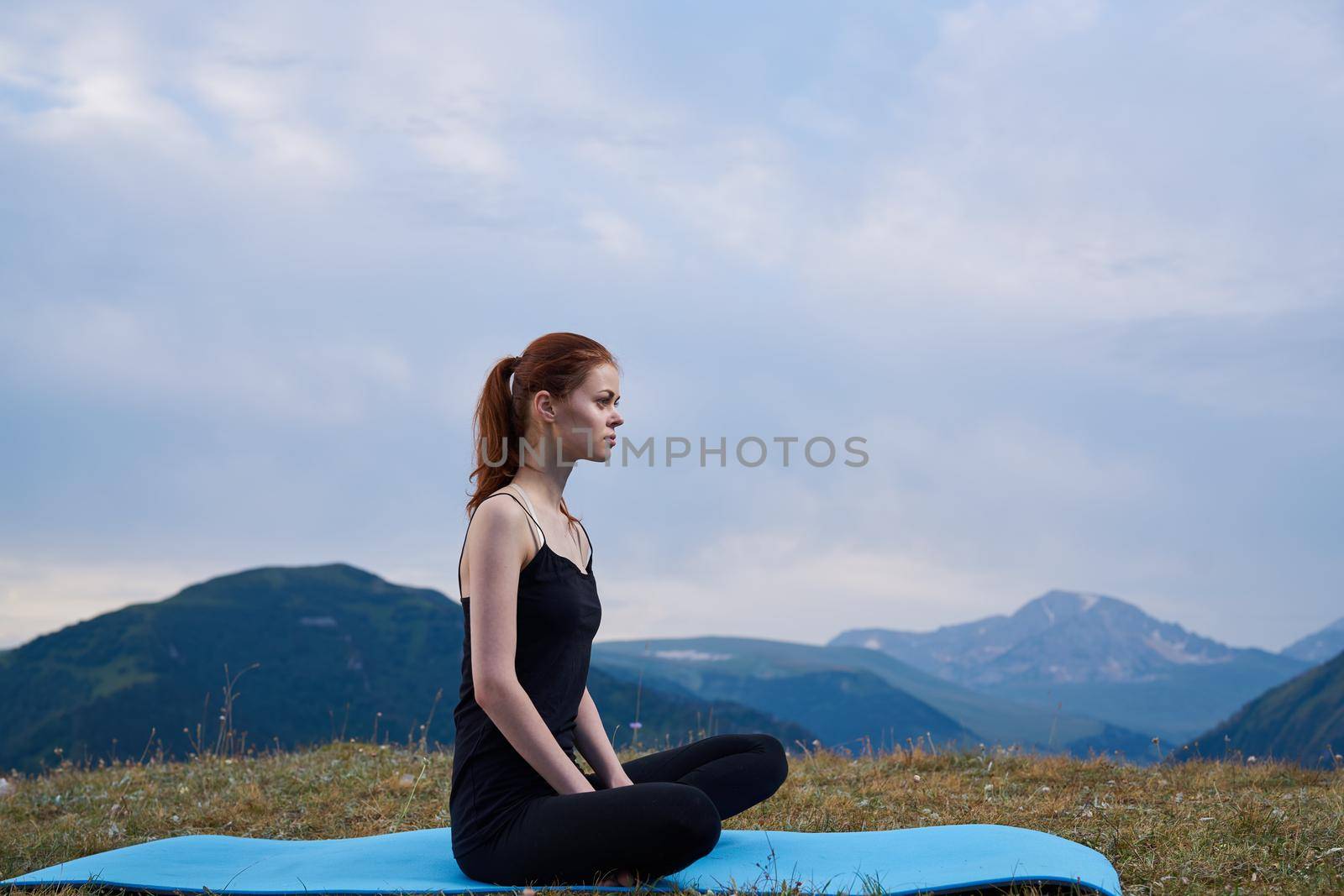 sportive woman workout meditation in the mountains outdoors. High quality photo