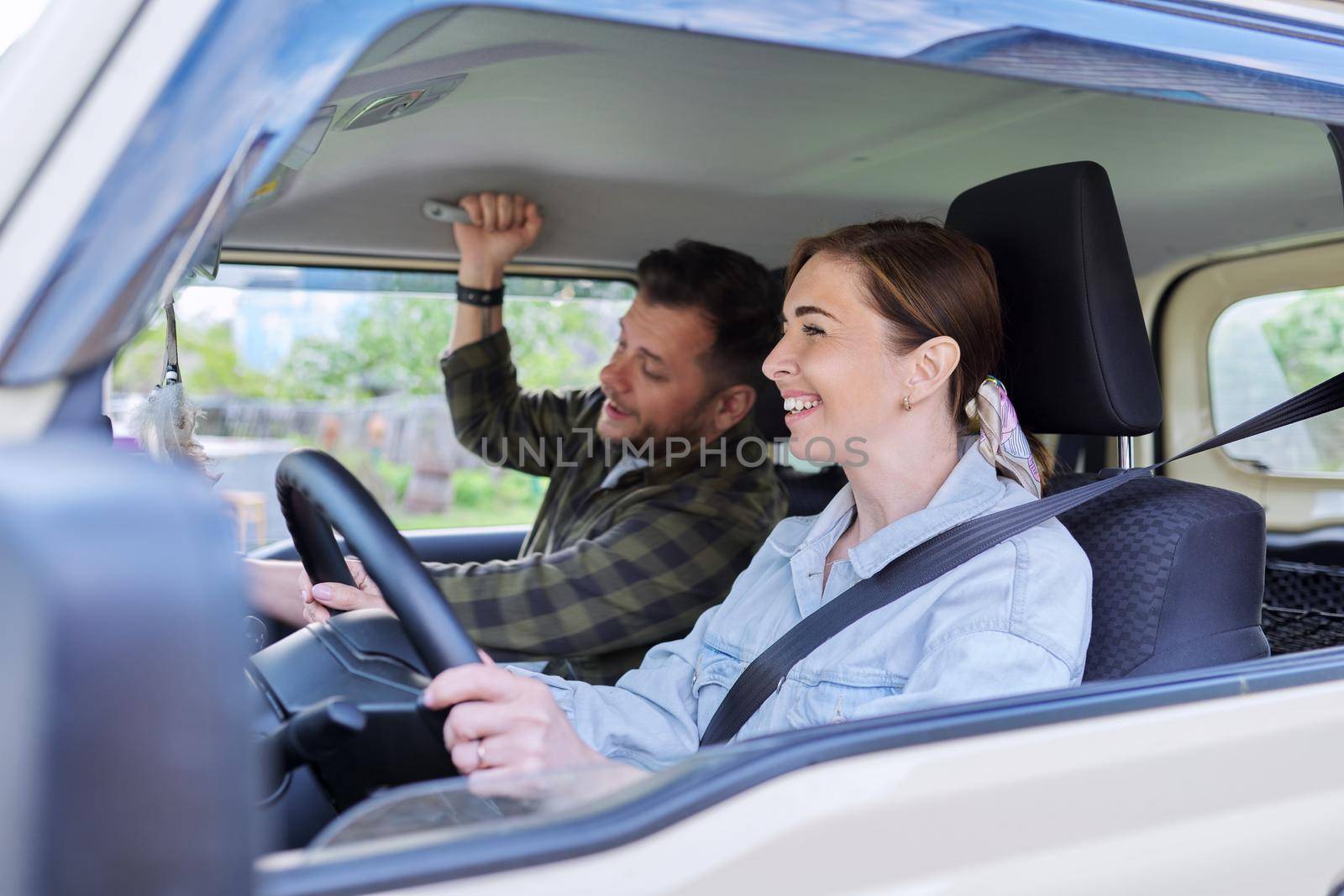 Middle age couple riding in car, woman driver man in passenger seat by VH-studio