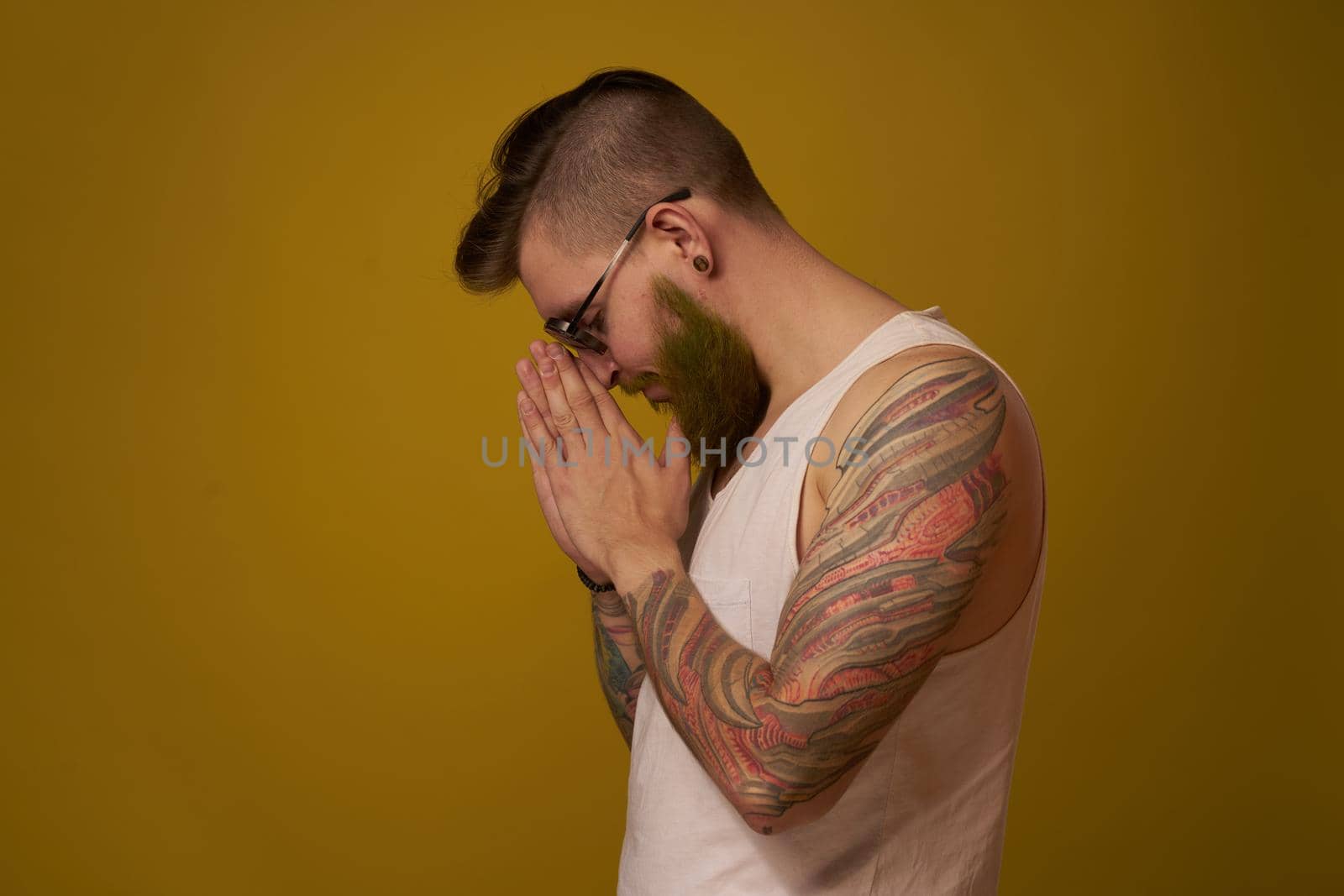 man in a white t-shirt tattoos on his arms fashion glasses modern style. High quality photo