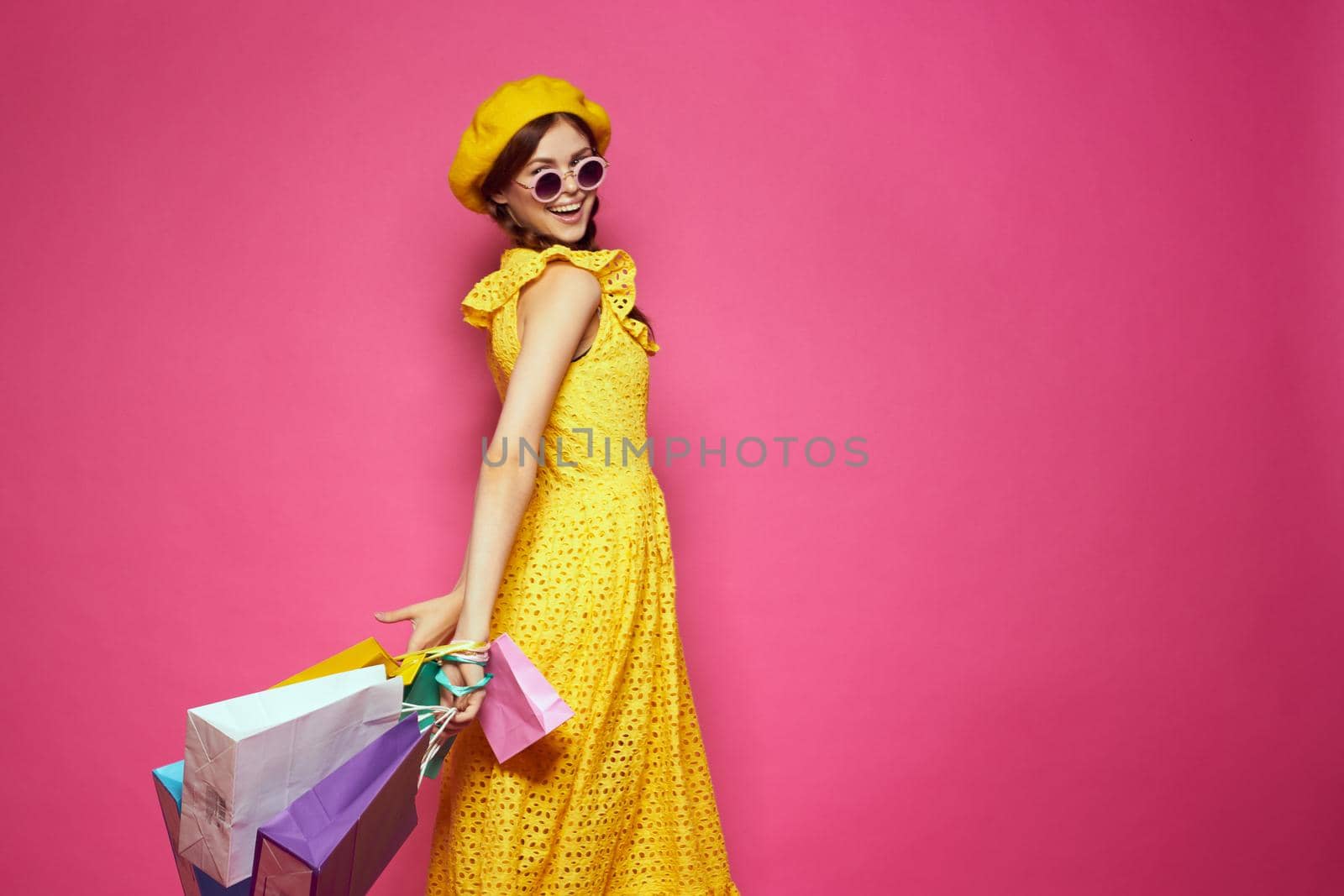 glamorous woman in a yellow hat Shopaholic fashion style pink background. High quality photo