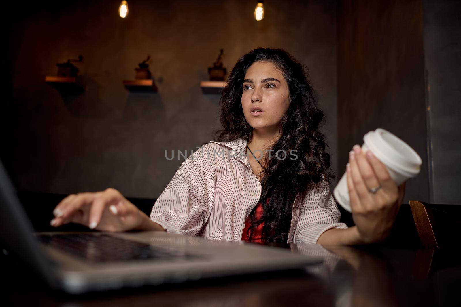 woman sitting in a cafe with a laptop coffee cup vacation by Vichizh